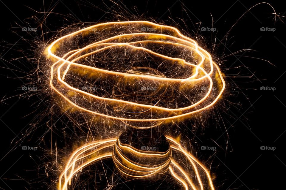 Light painting with a sparkler circling around a glass ball