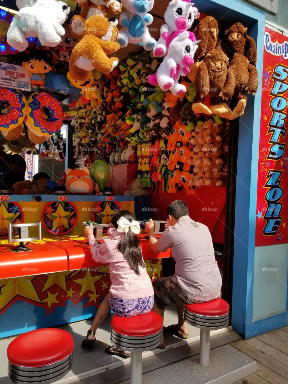 Busy with boardwalk games. Need to win to get a stuffed toy animal.