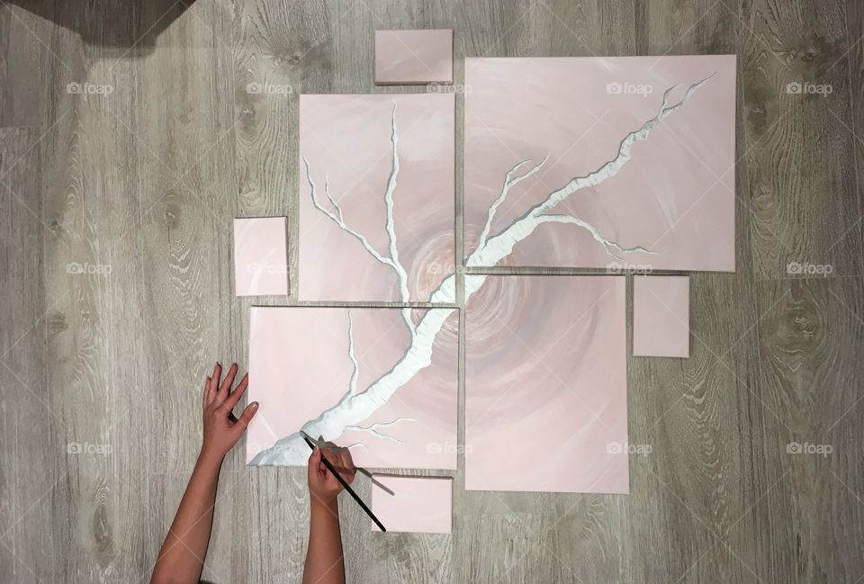 A woman drawing on multiple canvas