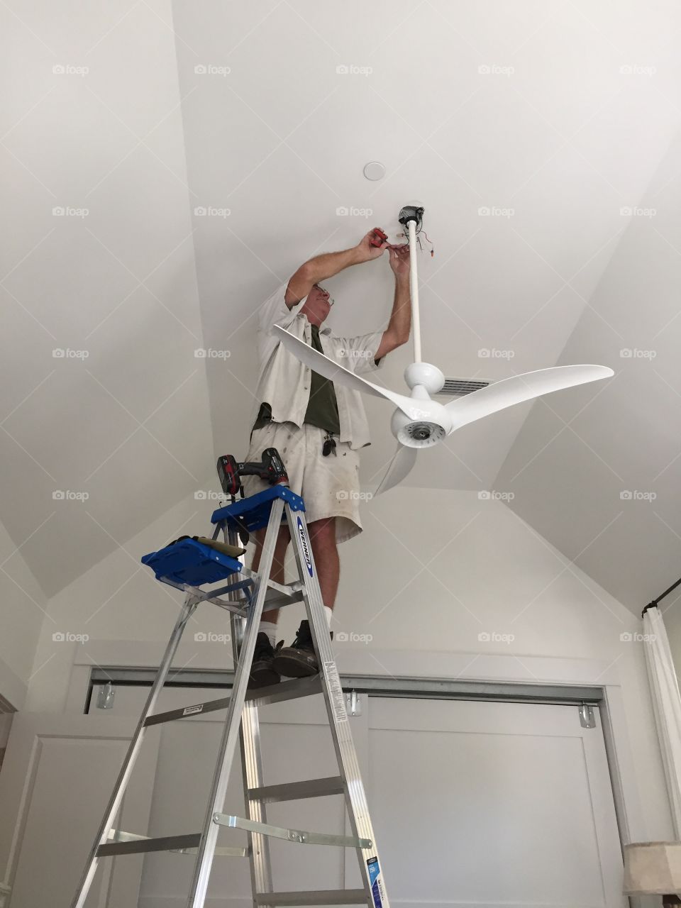 Man working and the hanging a ceiling fan
