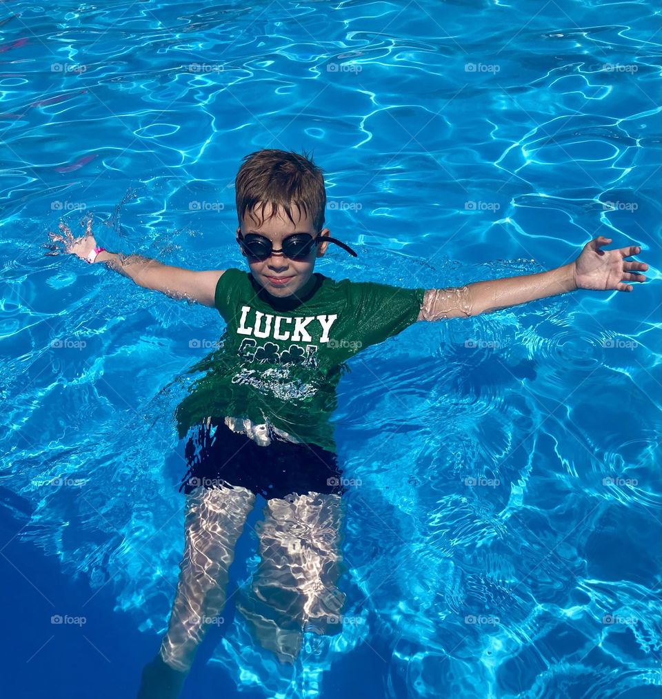 a boy swims in the pool