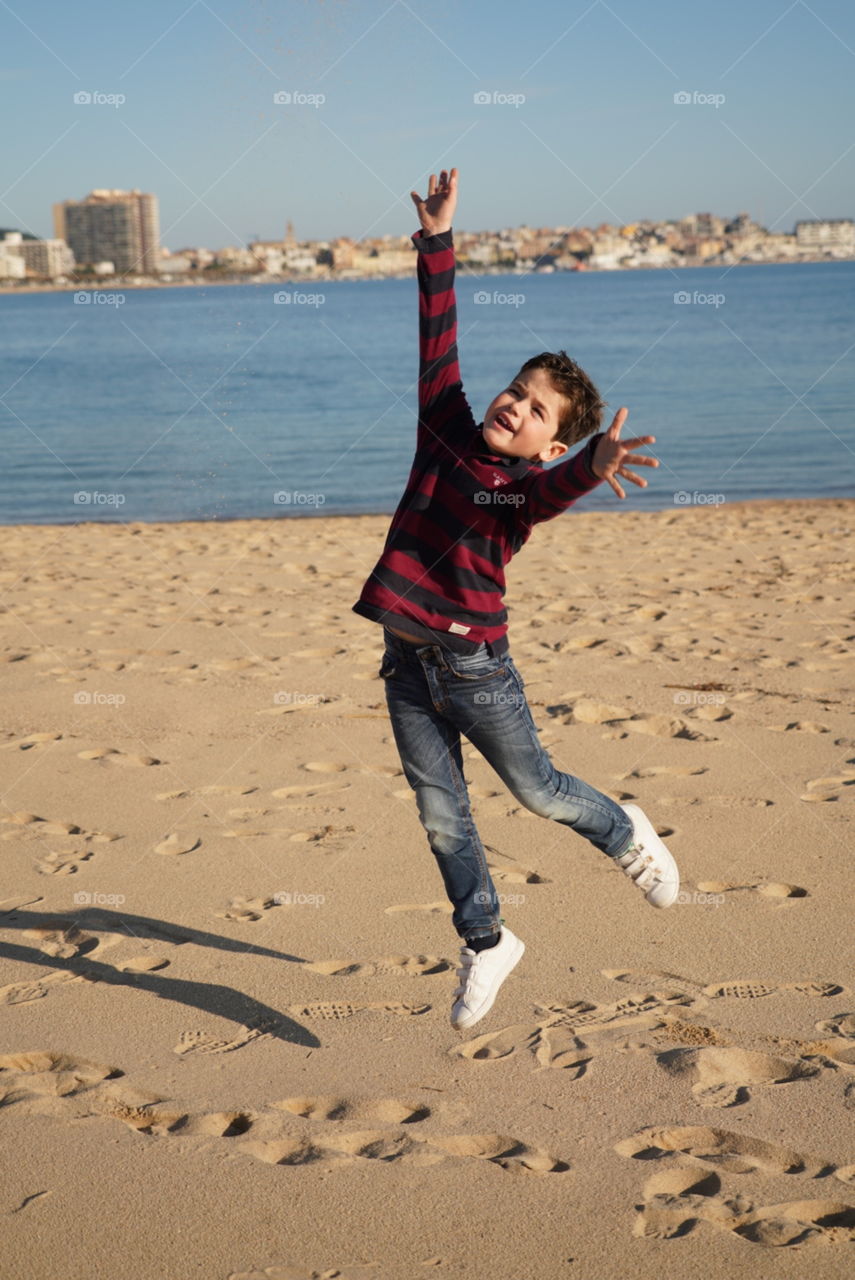 salto niño alegria en la playa