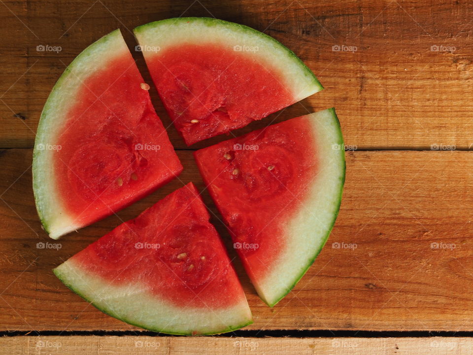 slices of watermelon lay flat on a wooden tray