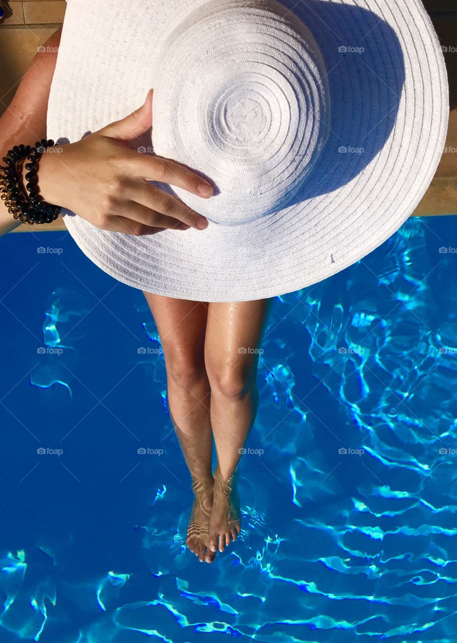 Woman with hat in a pool