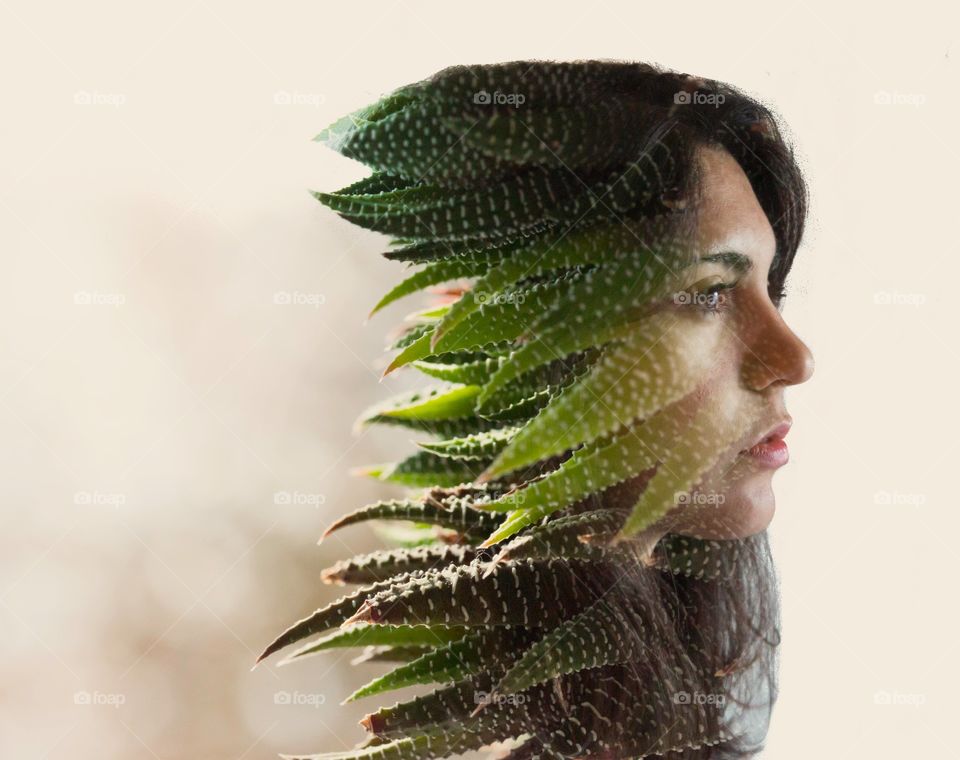 Multiple exposure of young woman with cactus leaves