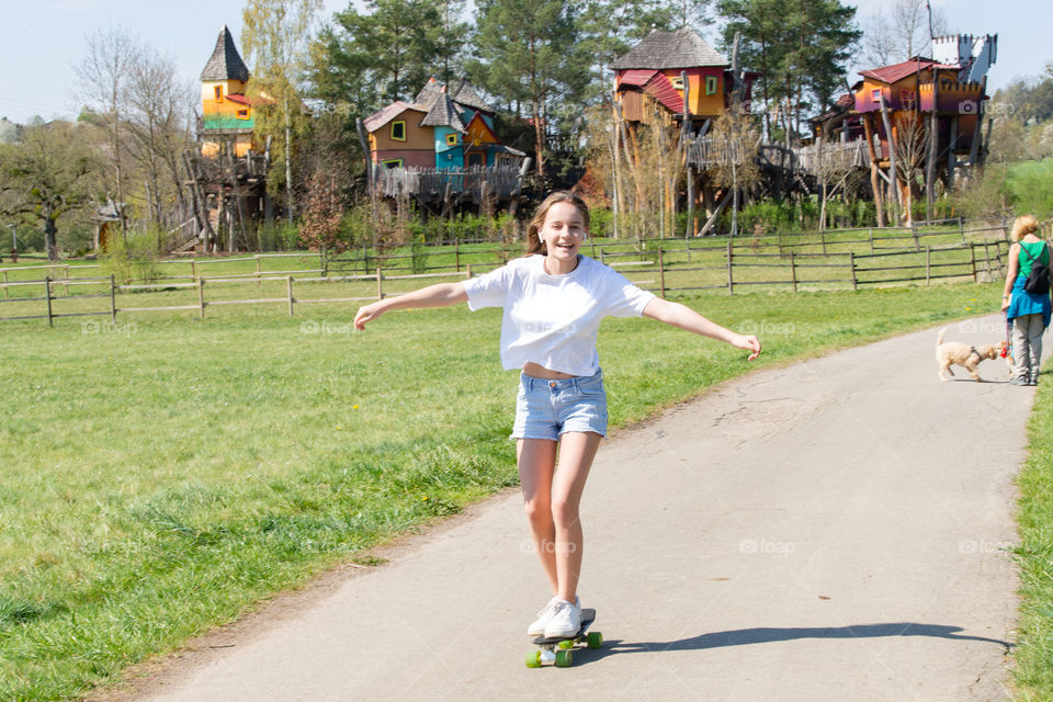 smiling and skating girl on a penny board