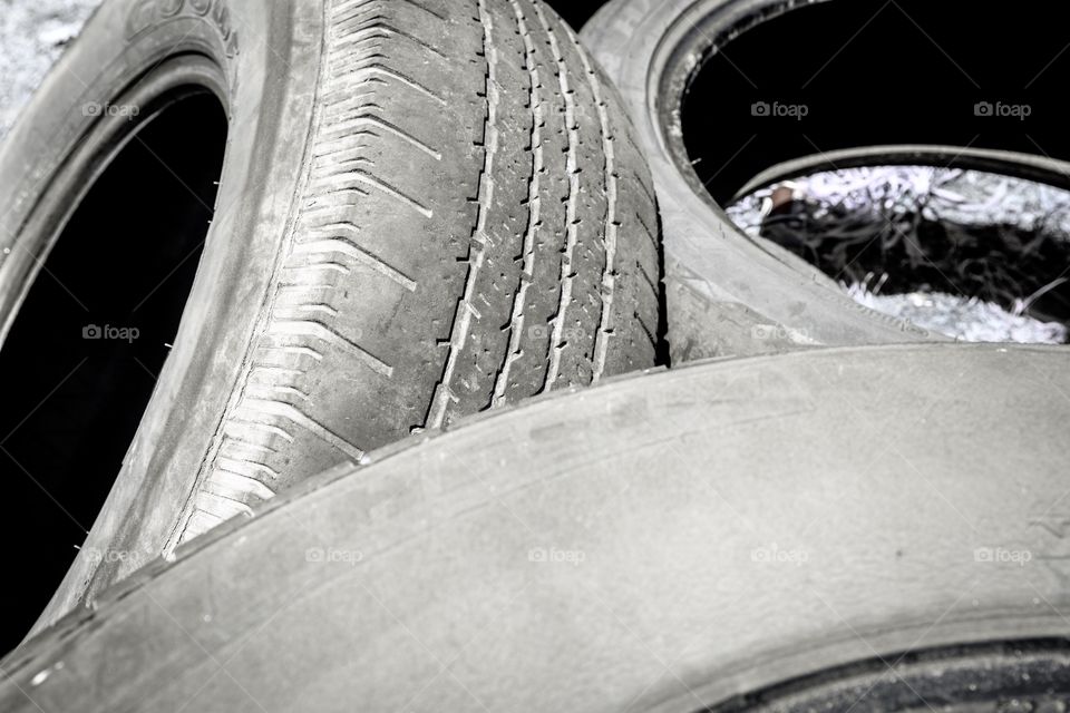 Background photo of used tires stacked on top of one another in closeup