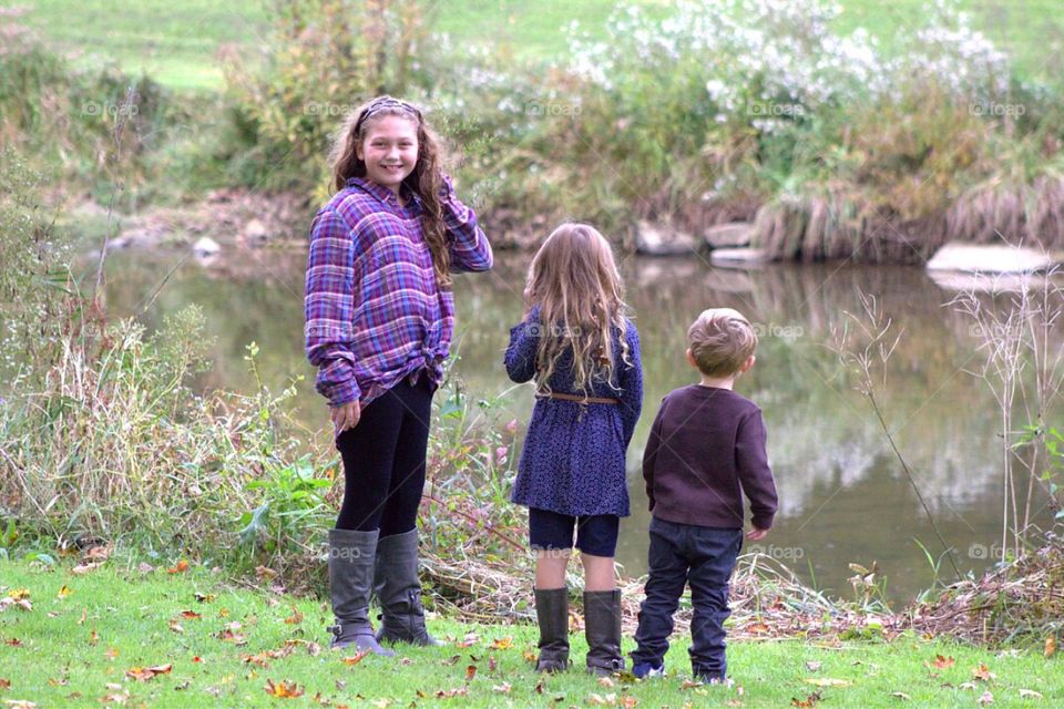 Sibling standing near lake