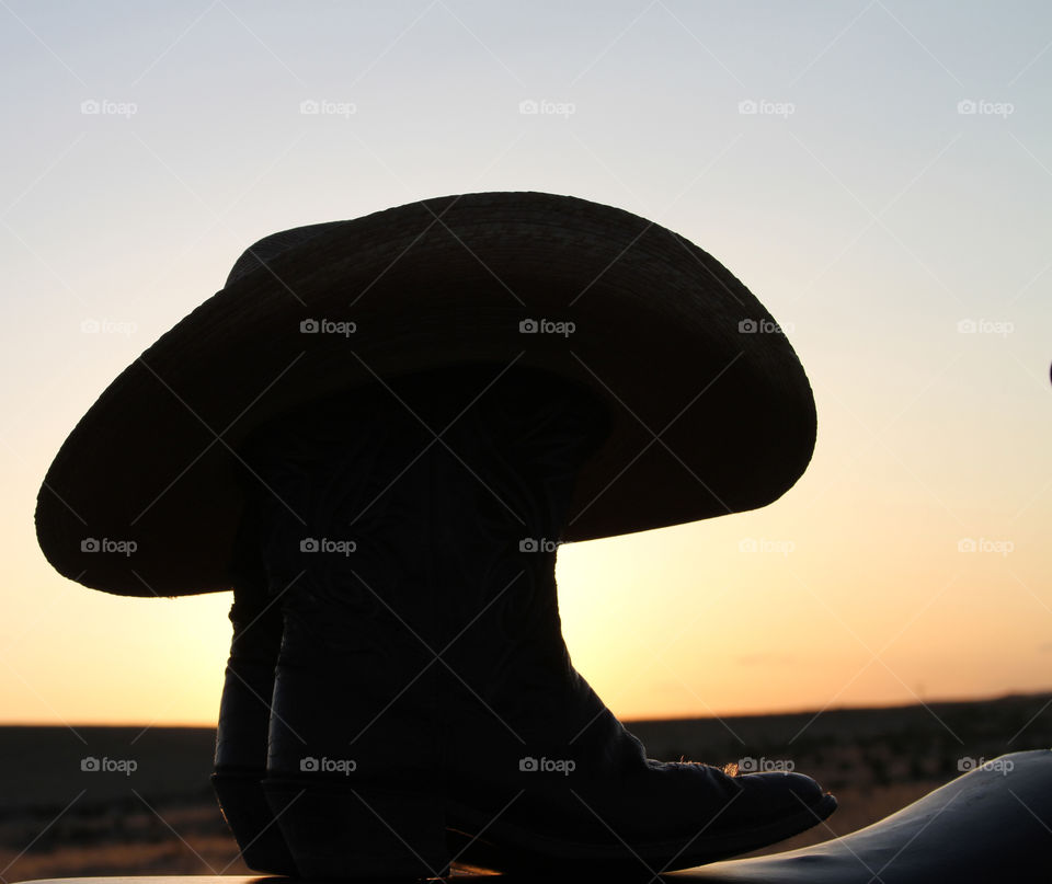 Cowboy boots and hat with wyoming sunset
