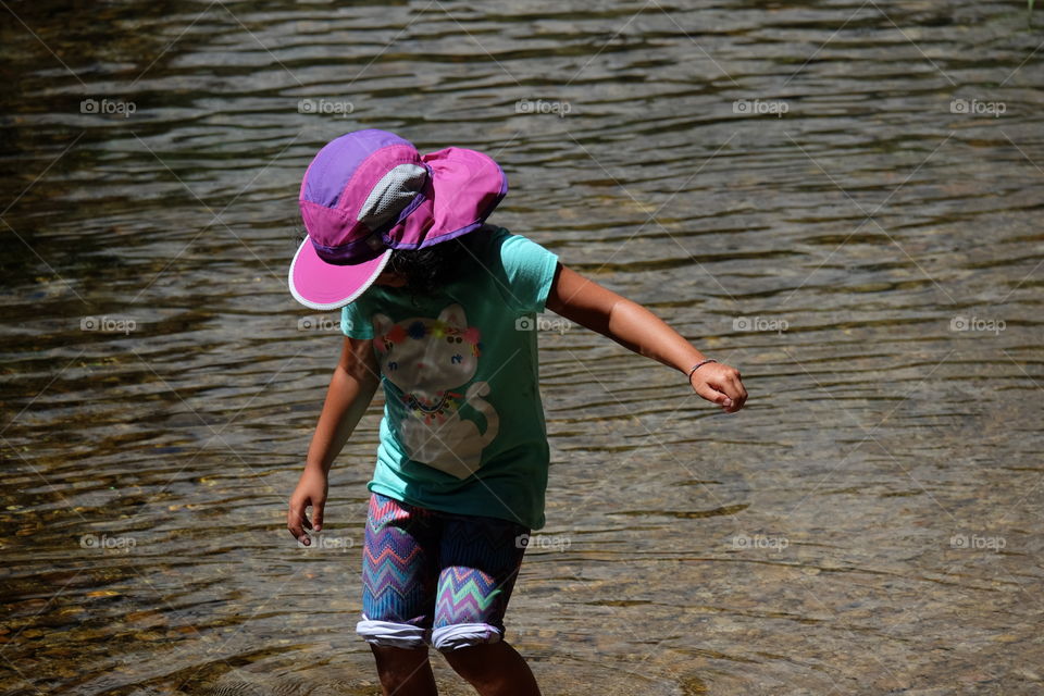 Girl exploring water in a river