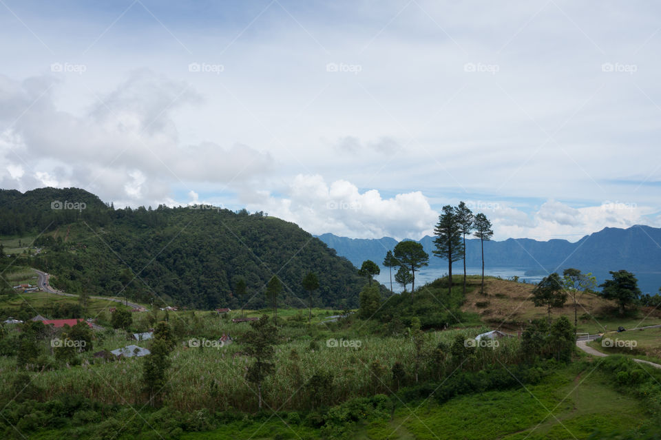 Beautiful view of Maninjau lake in west Sumatera, surrounded by green hills with clear blue sky