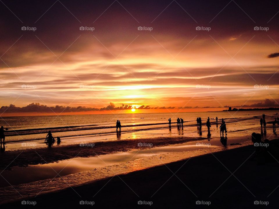 Silhouette of people enjoying sunset at beach