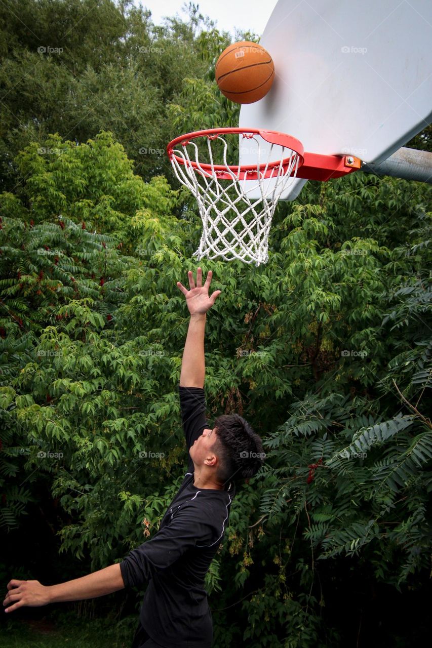 Young man is practicing his basketball skills