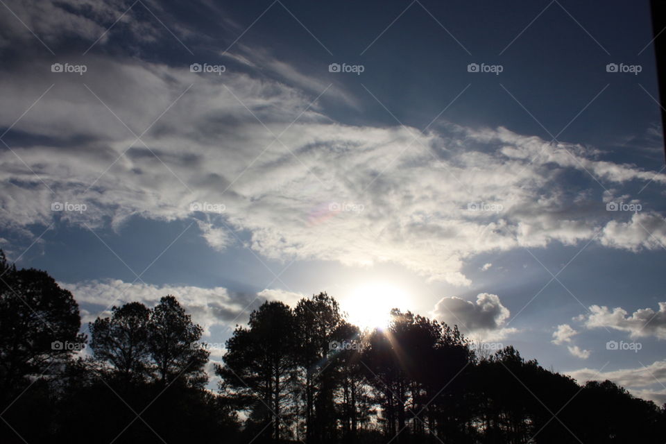 Tree line silhouette sunset . Tree line silhouette with sunset partly cloudy on a most beautiful day