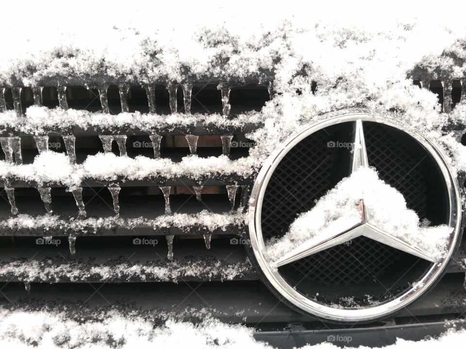 Mercedes car radiator grill in the snow and icicles