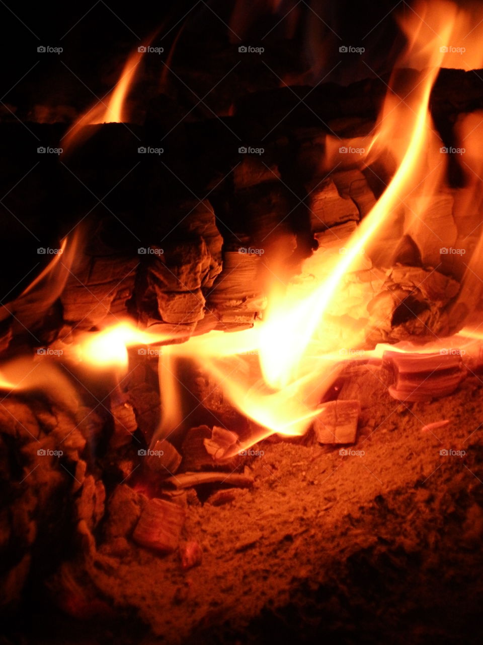 Warm cozy detailed close up of log fire and glowing coals.