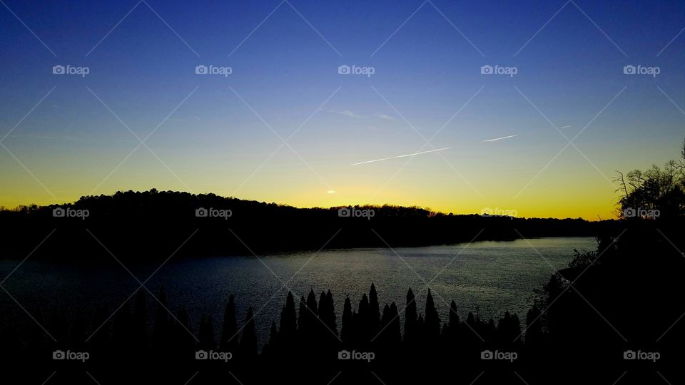 dusk on the lake with lines of clouds