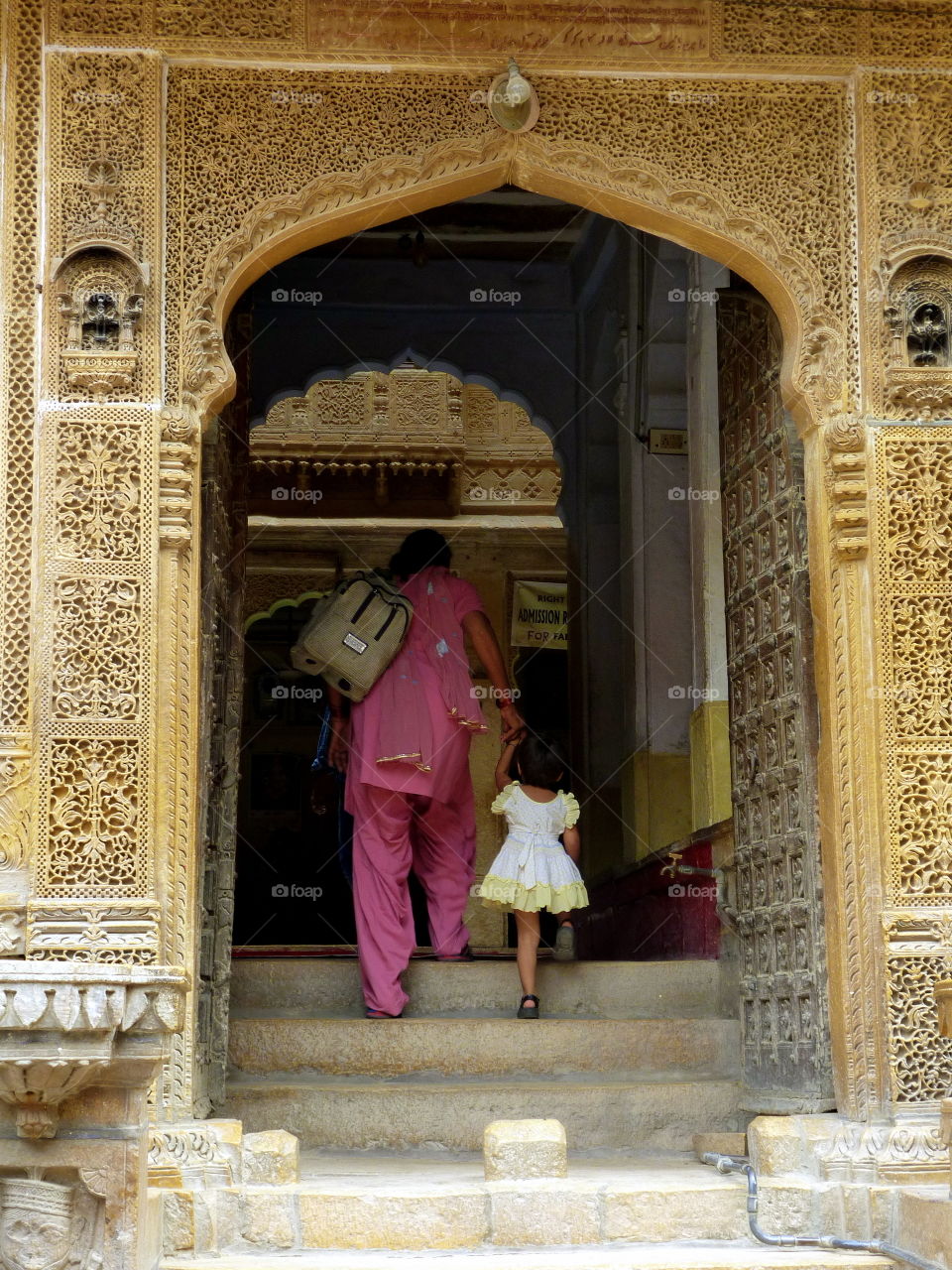 a woman and a girl entering in an indian palace