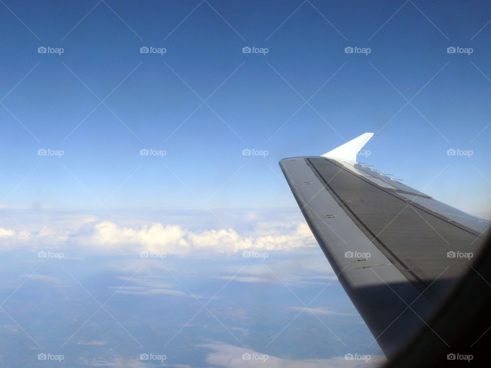 Airplane wing against cloudy sky over Spain.