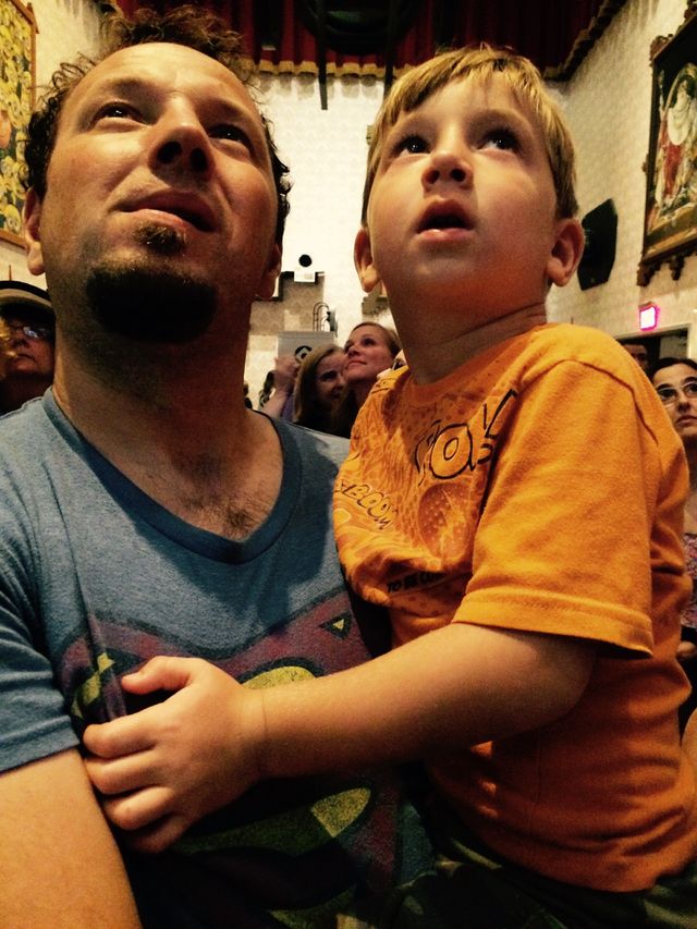 Waiting in line . Father and son looking at a screen