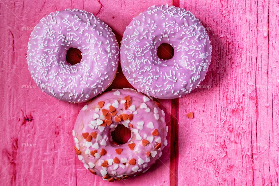 Three donuts on a pink table