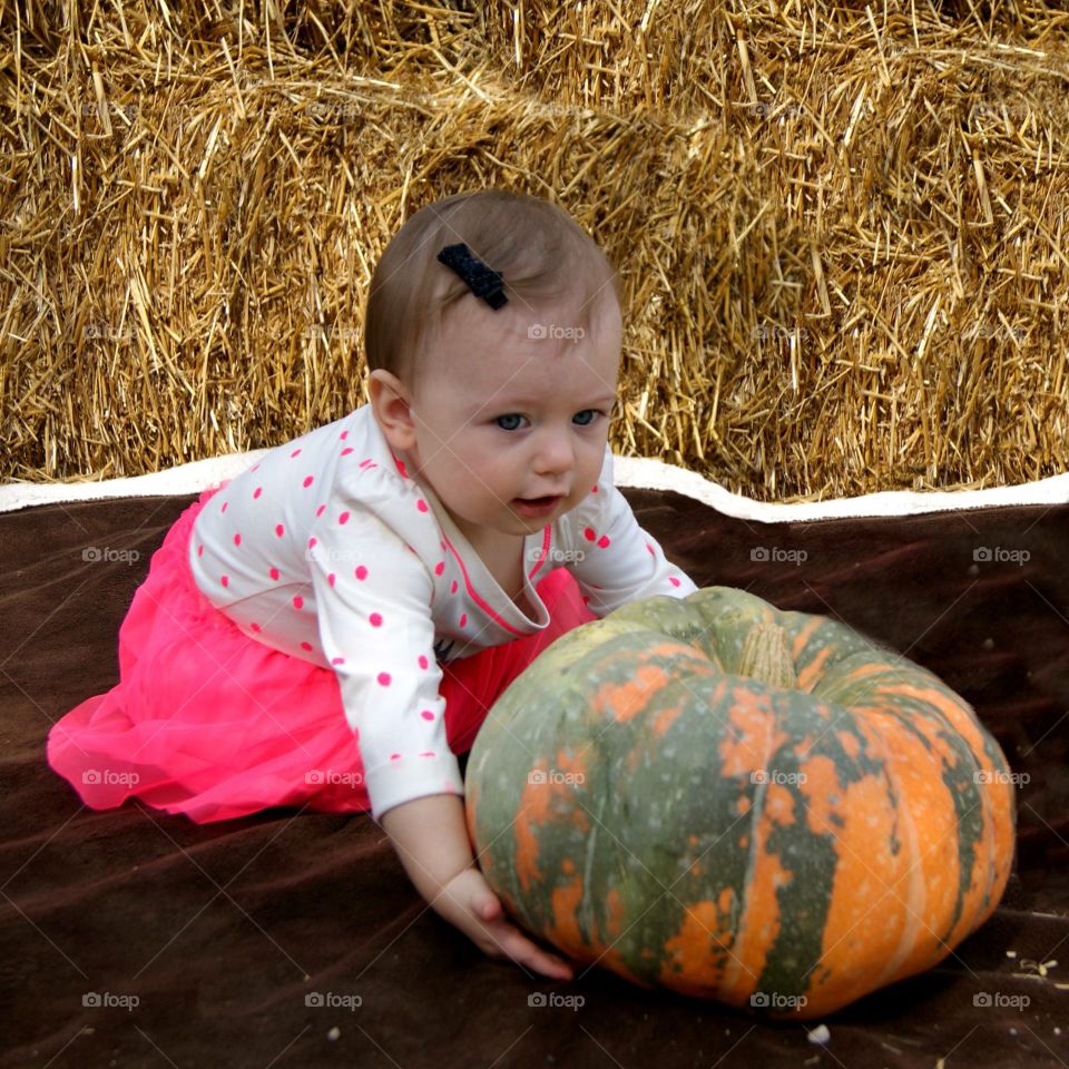 Close-up of a baby girl with pumpkin