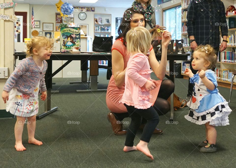 Mother and daughters playing with bubble wand