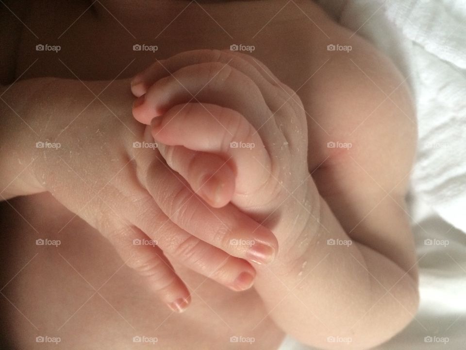 Cute baby hands clasped