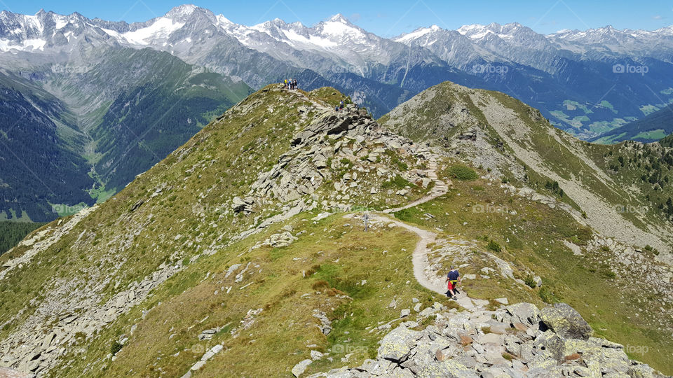 Hiking at high altitude in the mountains with panoramic view over mountain peaks 