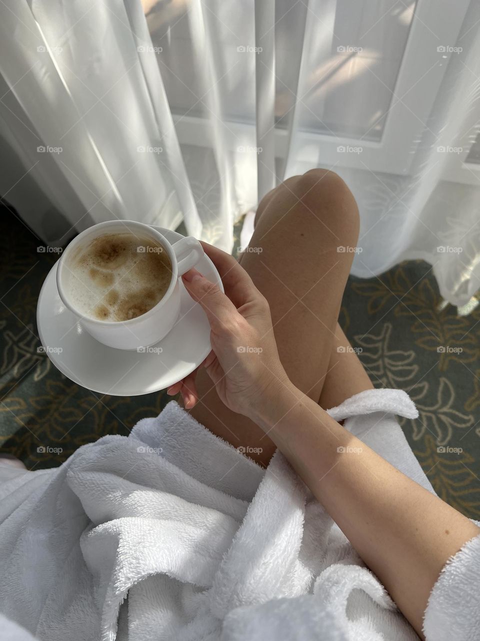 Woman holds morning coffee at the hotel room
