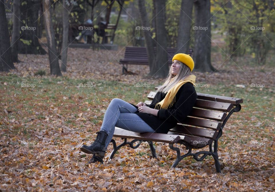 A woman on the bench in autumn park