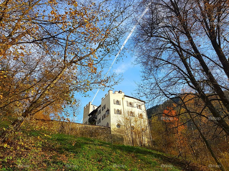 Burg im Zillertal, Österreich, herbstliche Stimmung, strahlend blauer Himmel, Burg umringt von Bäumen