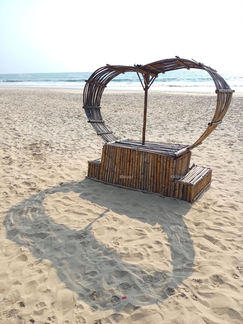 Heart shape bench seat on the beach it's looking beautiful with black colour heart shape shadow