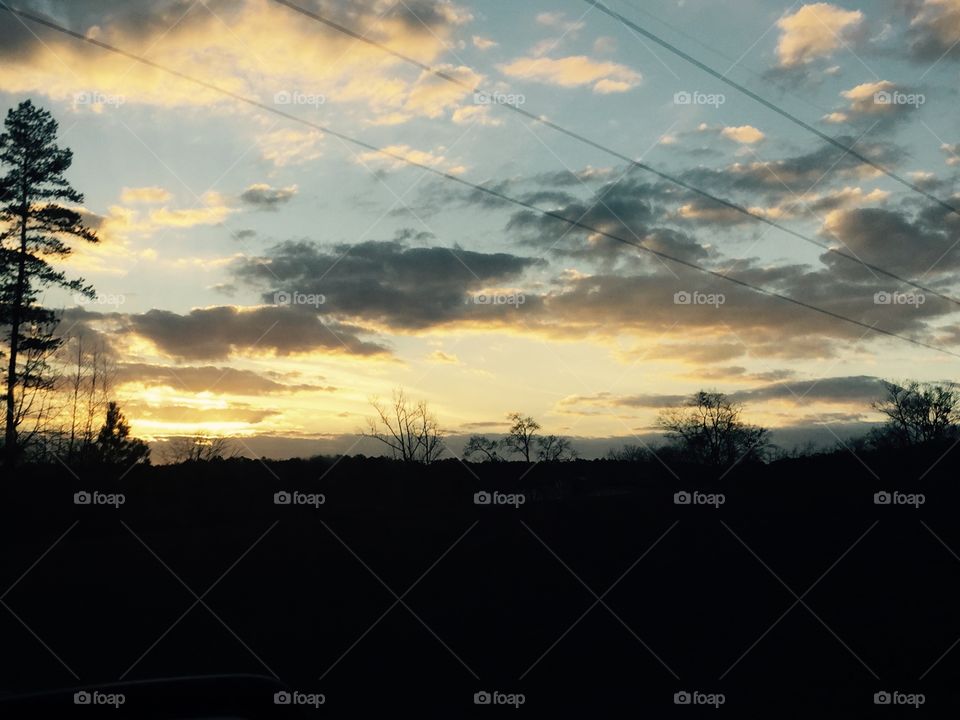 Sun setting in the sky in the winter. A yellow look against the blue sky.