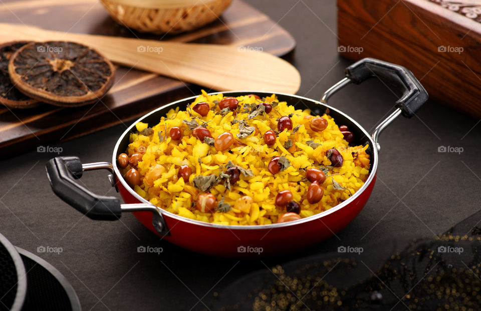Indian Food Poha in a wok on black background