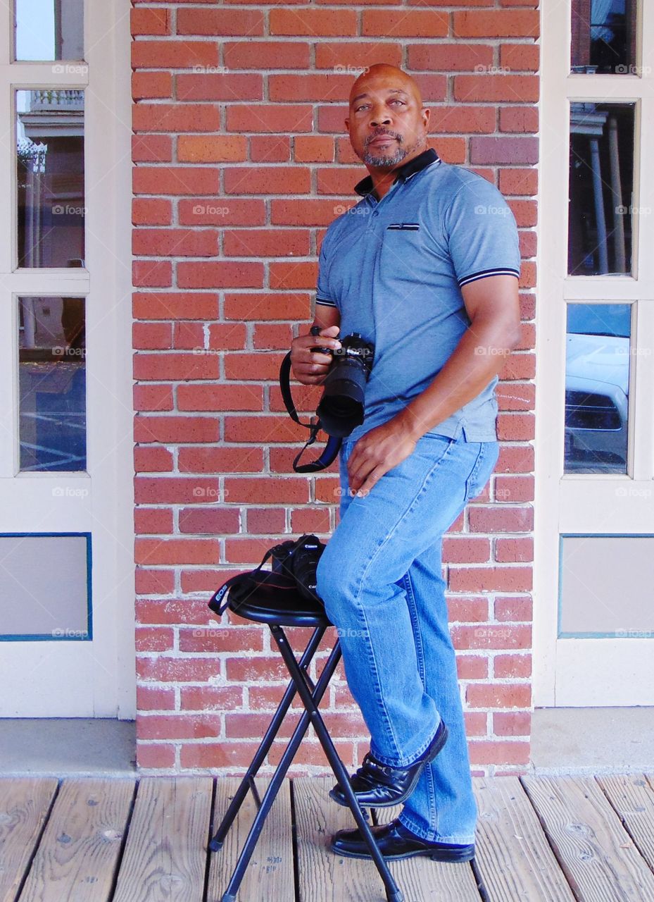 Photographer posing for the camera With camera in hand.