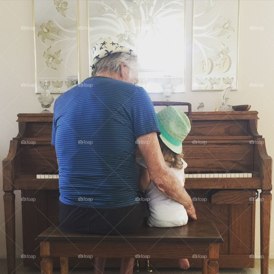 Grandpa and child with hats playing piano 