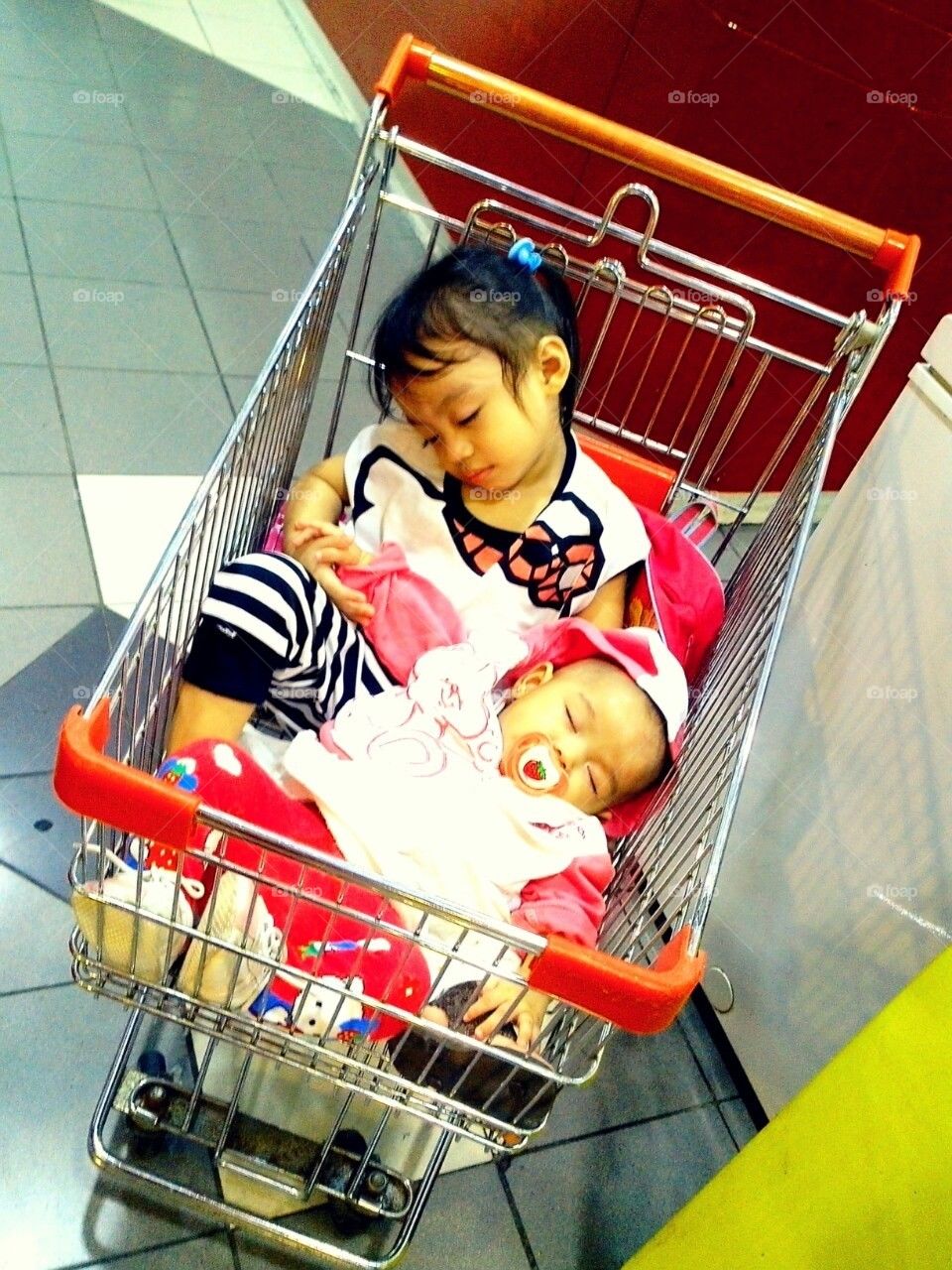 Two kids, siblings sleep in a grocery cart