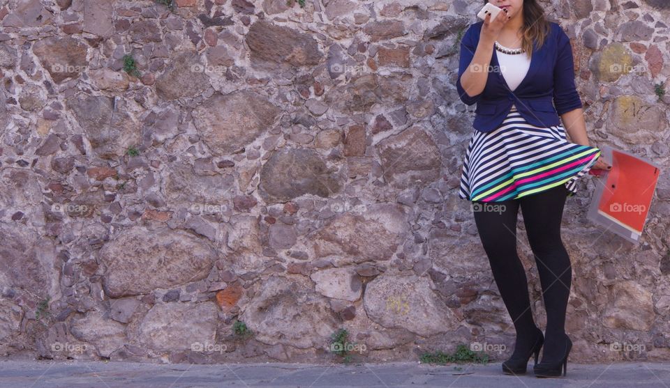 A candid capture of a young Mexican woman on the street wearing a colorful fashion outfit in San Miguel de Allende, Mexico.