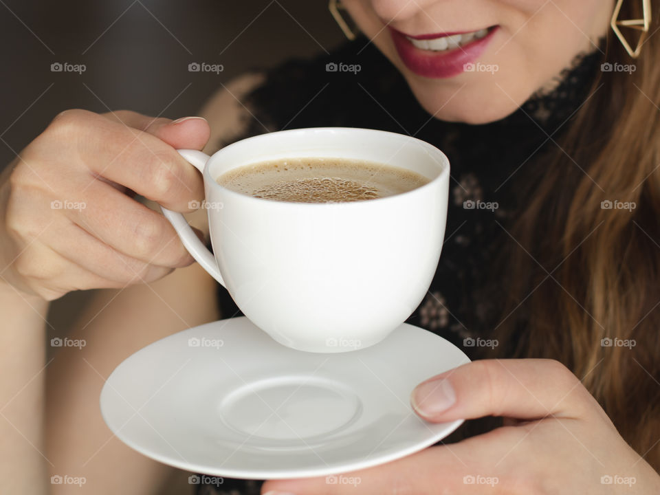 Young woman drinking coffee, white coffee cup