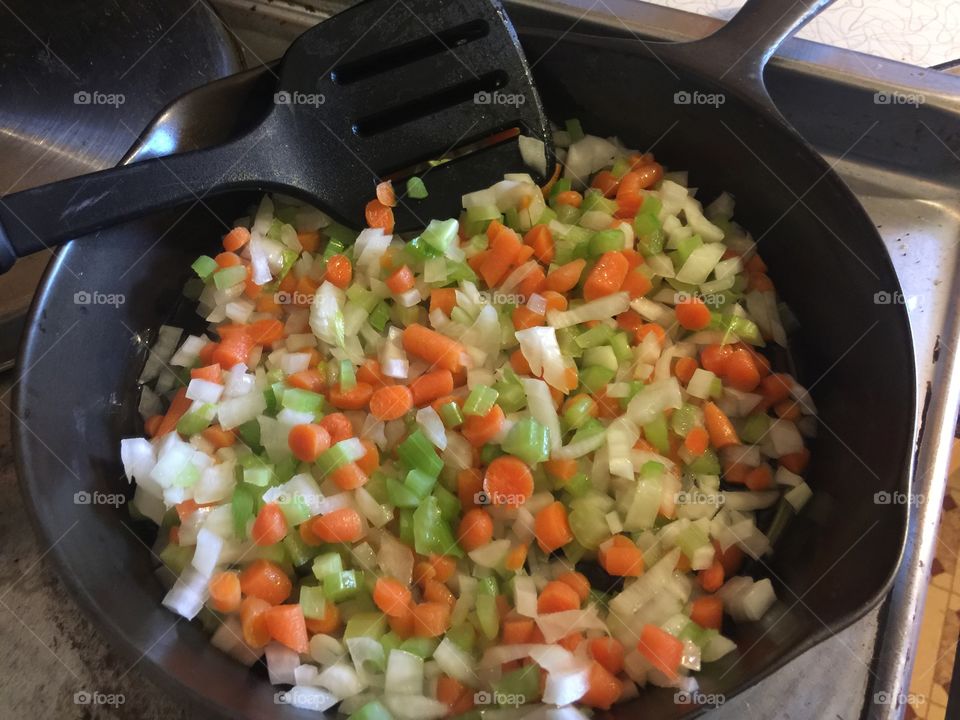 Trio of carrots, celery and onion in a cast iron pan