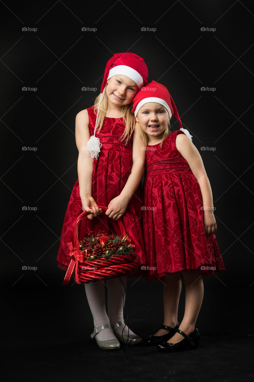 Two sisters posing for christmas portrait.