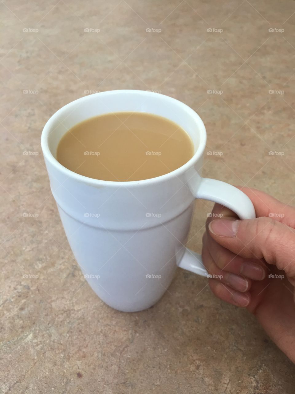 Hand holding a cup of coffee.