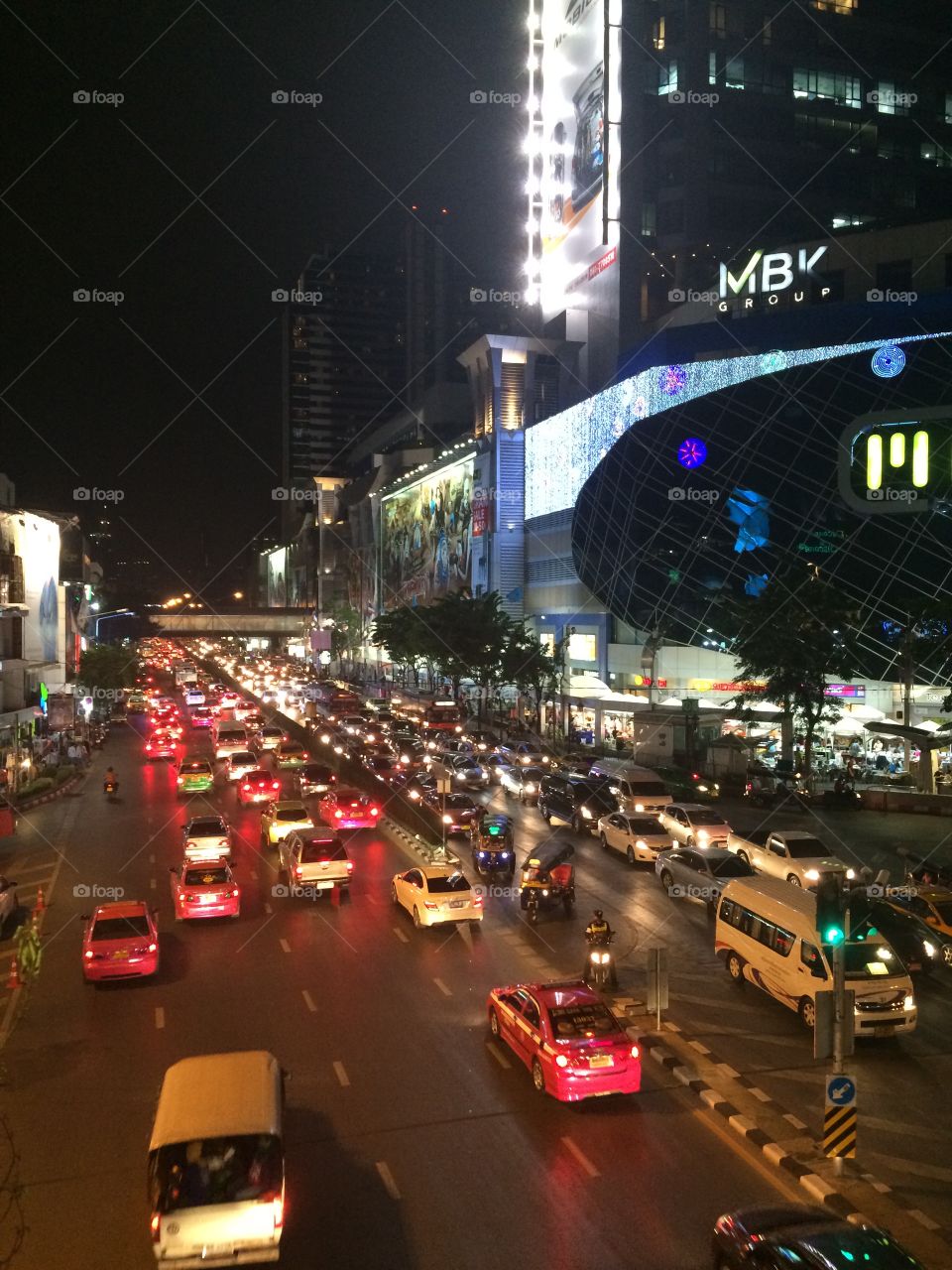 Bangkok, Thailand (MBK mall): hustle and bustle of street at night with taxis and motorbikes