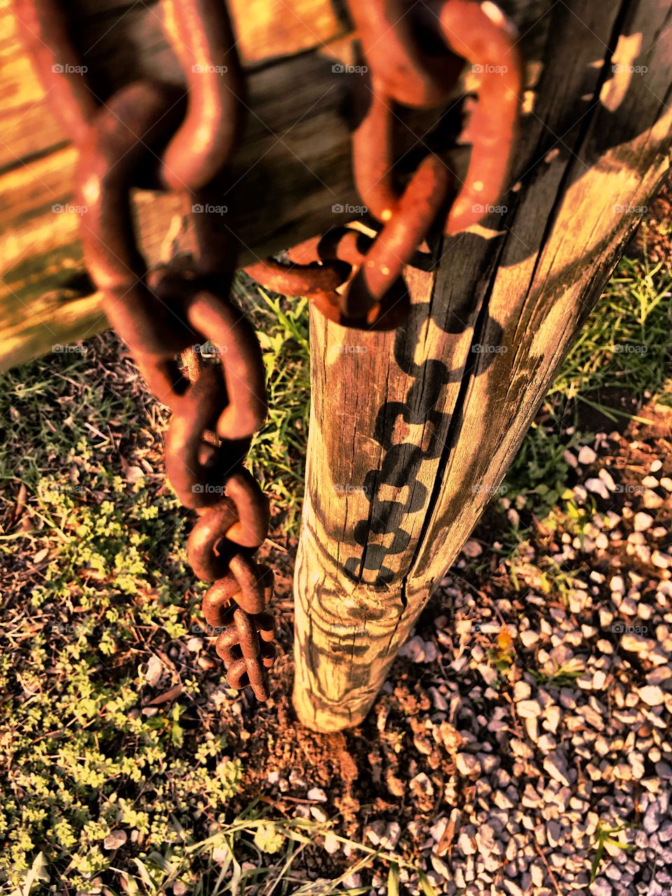 Rusted chain resting on weathered fence waiting for the next opportunity to work 