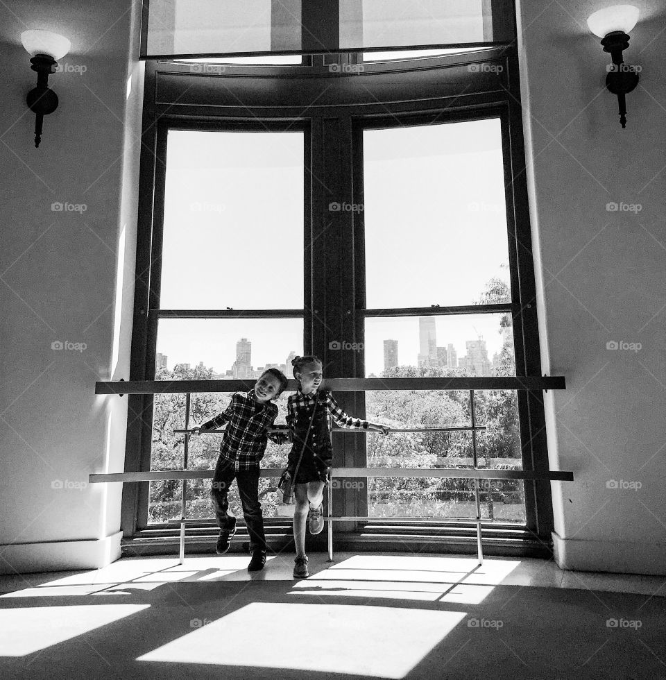Sibling standing near glass window