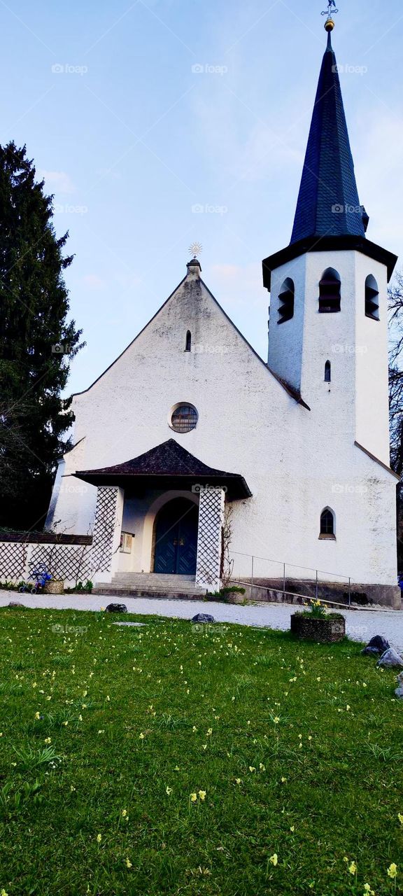 A church in the famous little town of “Garmisch Partenkirchen” in the Bavarian Alps has marked and unusual proportions. The upwards pointing rooftop over the arched entrance reminds of an Asian pagoda or temple. 2023. Hypnotic Productions