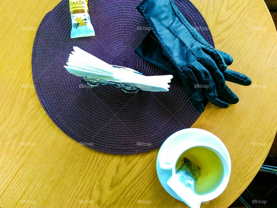 cup of green tea, gloves, wipes and paste on the table