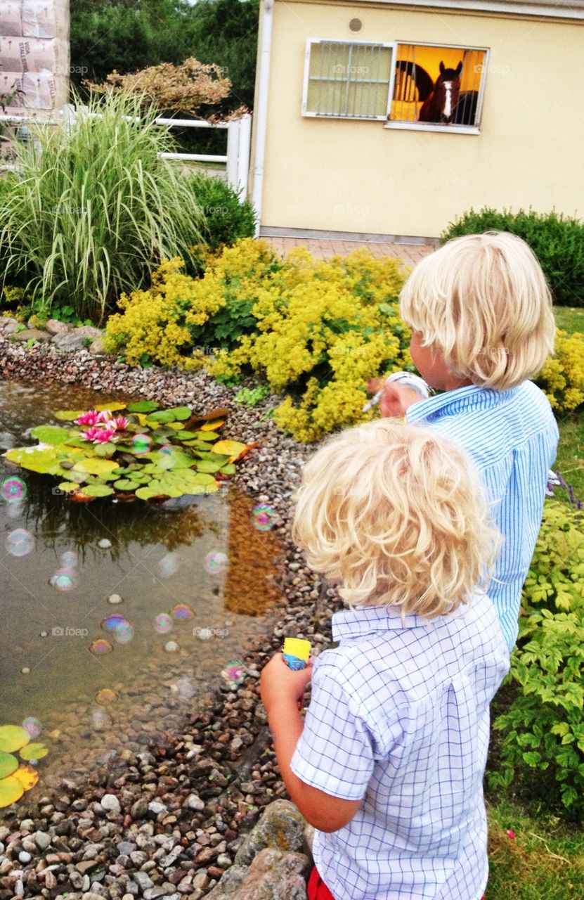 Boys from behind blowing bubbles