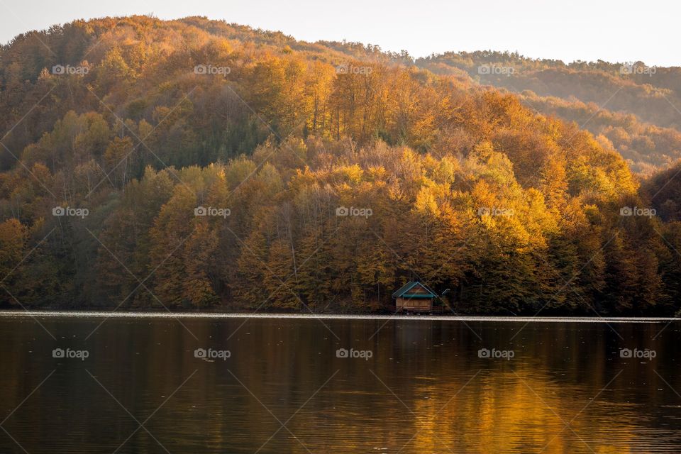 Little house on the lake in autumn